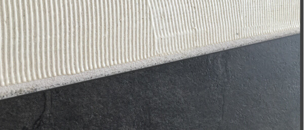 Nanesené lepidlo na stene pri lepení vinylovej podlahy na stenu