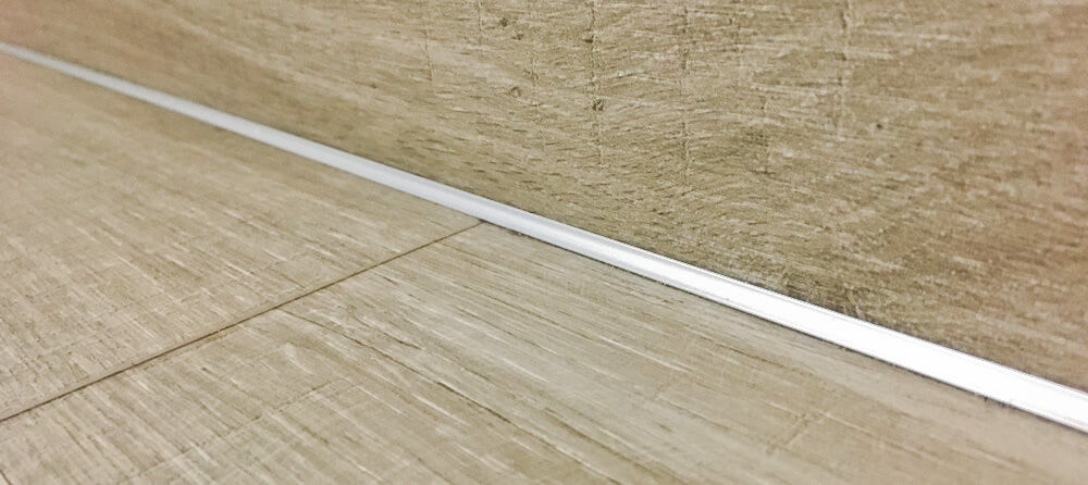 Detail vnútorného rohu na schodisku pokrytom lepenou vinylovou podlahou.