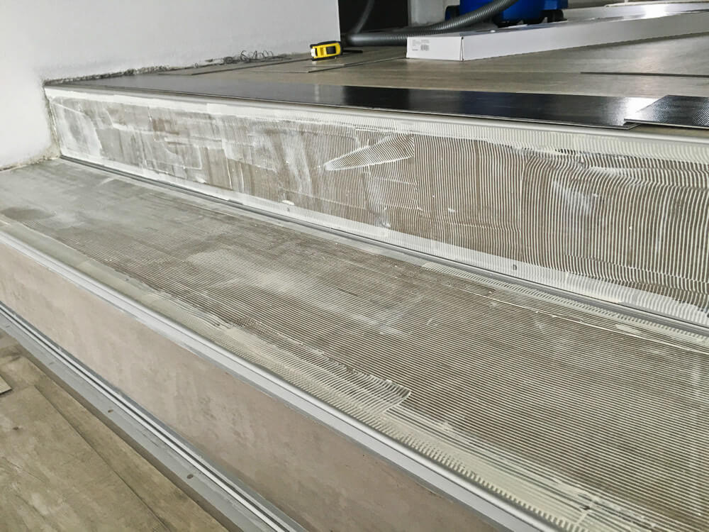 Nanesené lepidlo pre nalepenie vinylu na vyspravené schodiskové stupne a podstupnice.